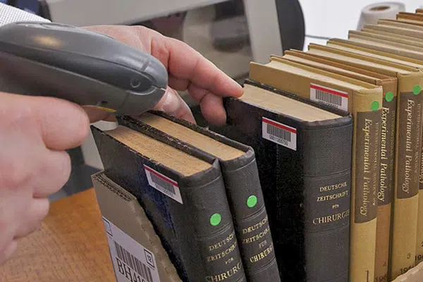 Interlibrary loans | An image of a librarian scanning in interlibrary books on loan